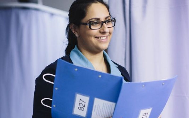 Nurse holding a clipboard and smiling