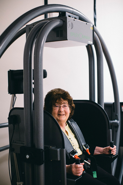 A woman sitting in the Epley Omniax Positioning System