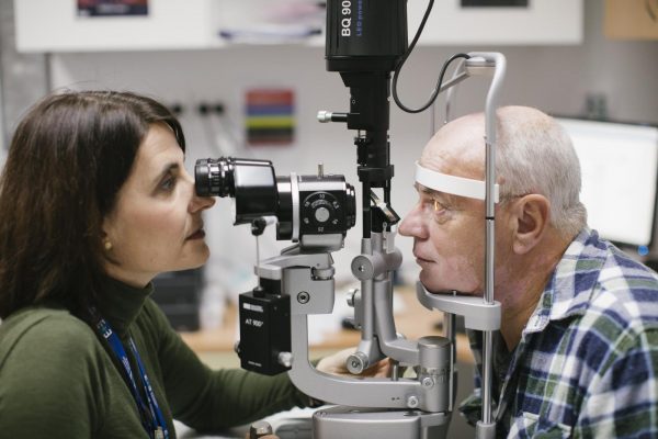 A clinician checking a patient's eyes