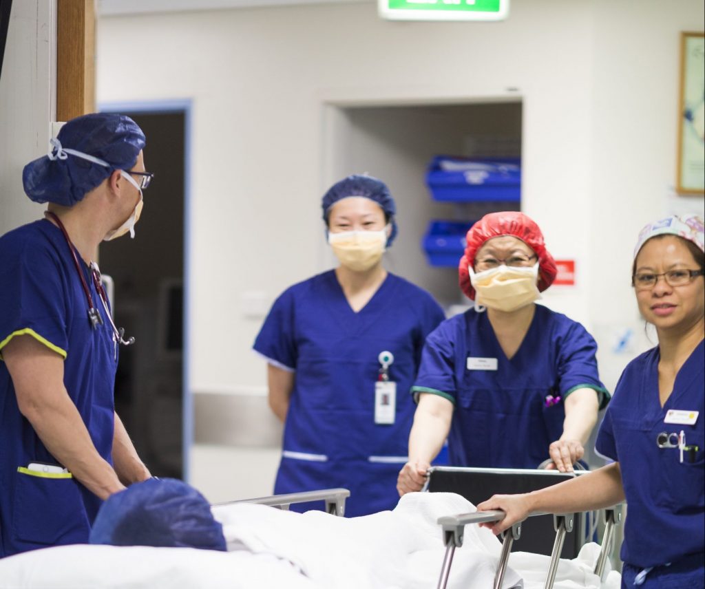 Medical staff pushing a patient in a bed