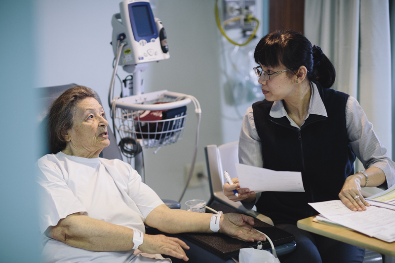 Nurse treating a patient in hospital bed