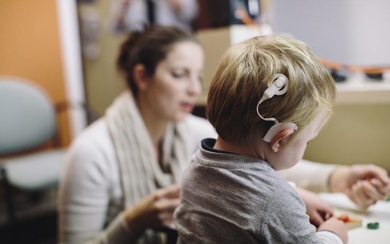 child learning to hear, shown wearing a cochlear implant