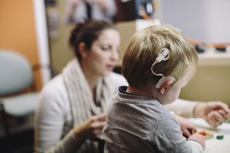 child learning to hear, shown wearing a cochlear implant