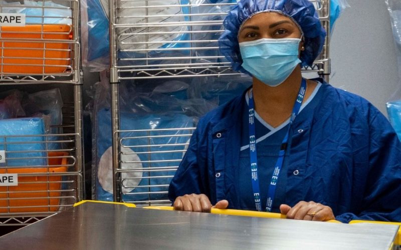 Staff member smiling, wearing mask in medical department.