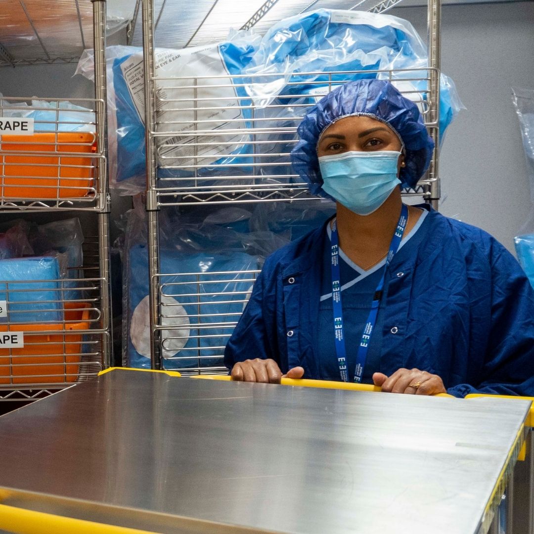 Staff member smiling, wearing mask in medical department.