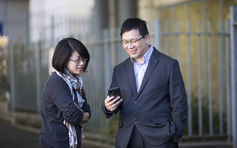 Two people looking at a smart phone