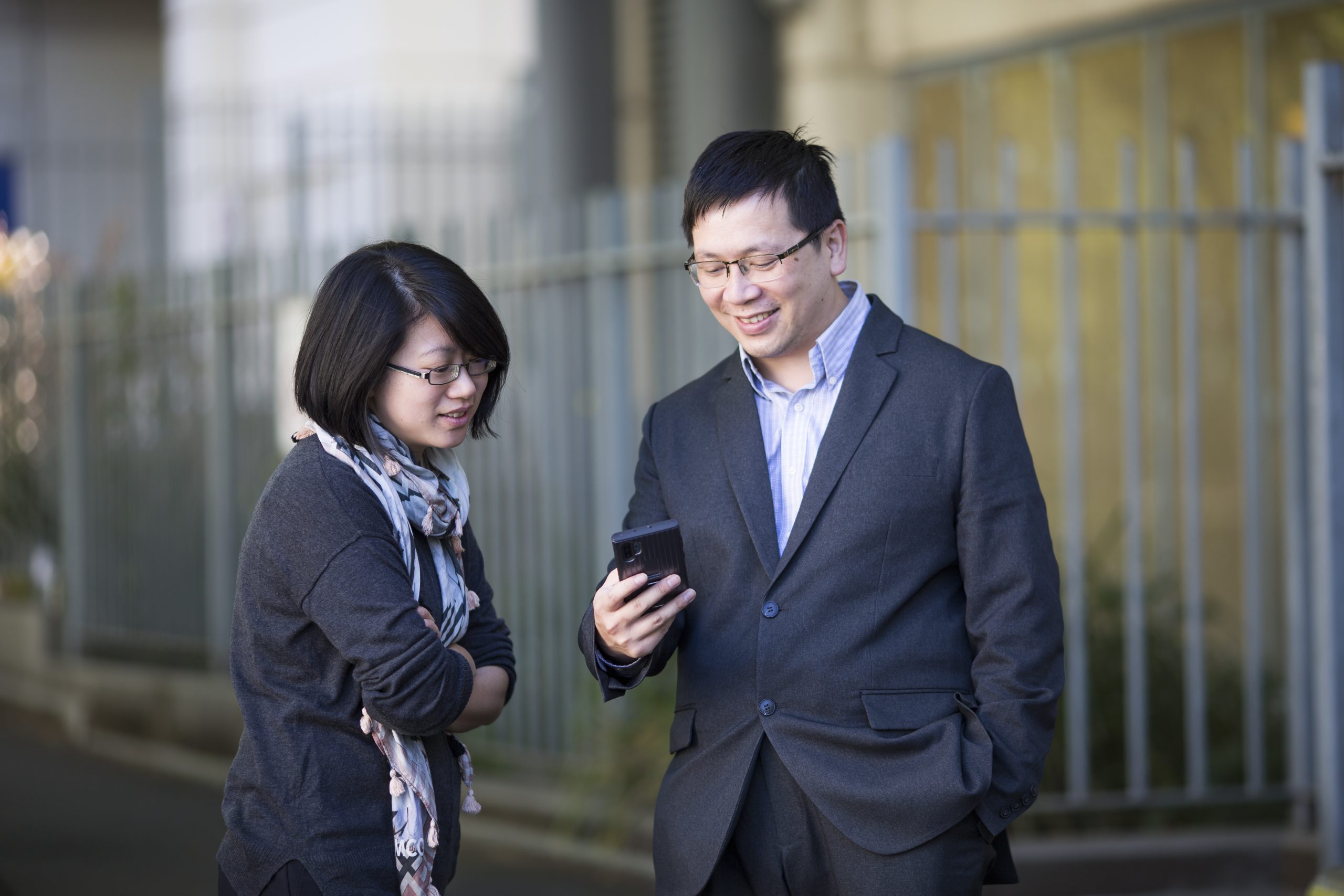 Two people looking at a smart phone