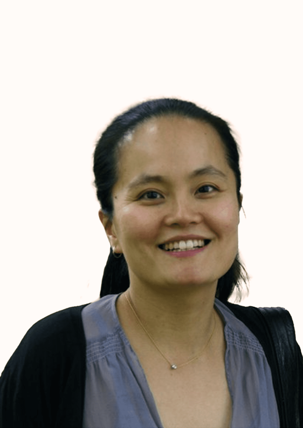 Young lady smiling, with long back hearing wearing a black sweater and grey blouse