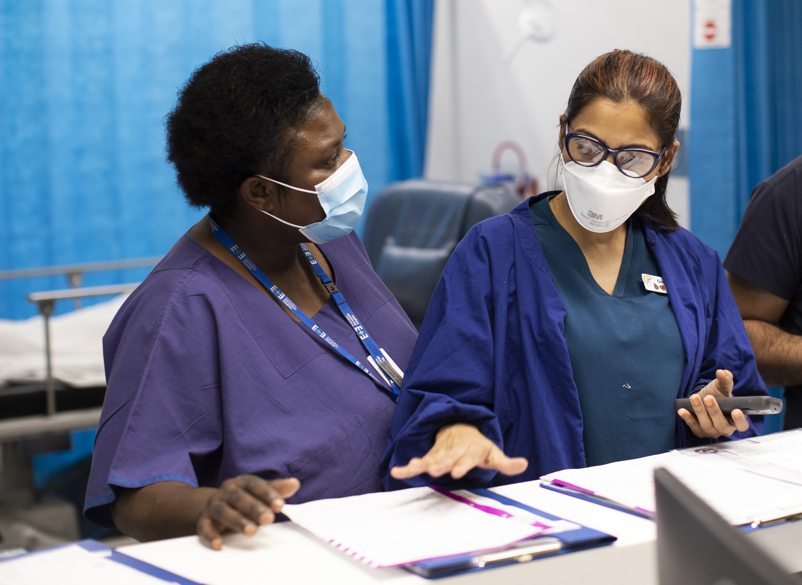 Two medical staff conversing over a patient chart
