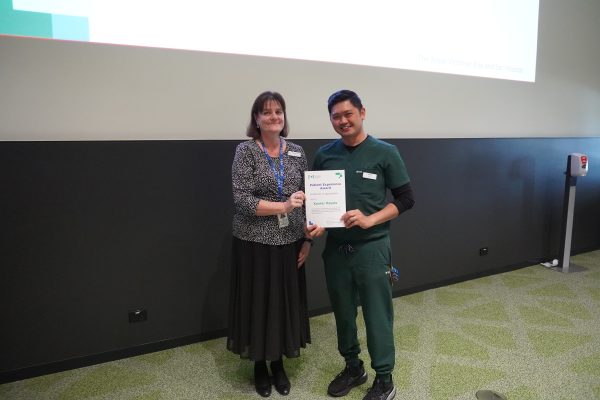 Executive Director Operations and Chief Nursing Officer, Leanne Turner, standing next to nurse Xavier Reyes, holding a certificate.