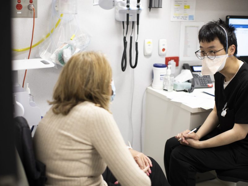 A patient with a nurse sitting together in a consultation room undergoing a pre-surgery check