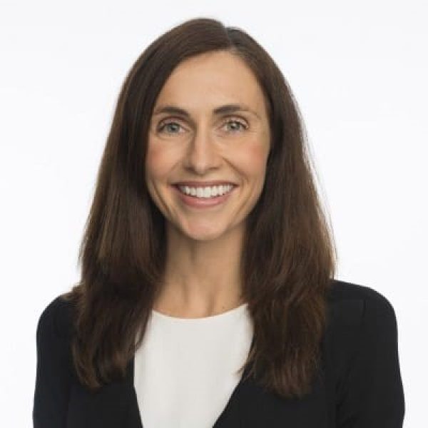 Headshot of Dr Amy Cohn against a white background. She wears a white top and black blazer.