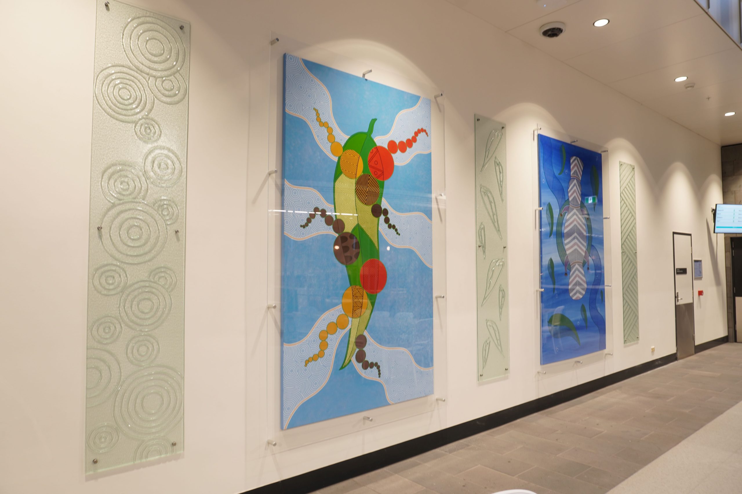 Our Aboriginal art installation in Cafe 1863 featuring two colourful paintings and three Wathaurong glass panels.