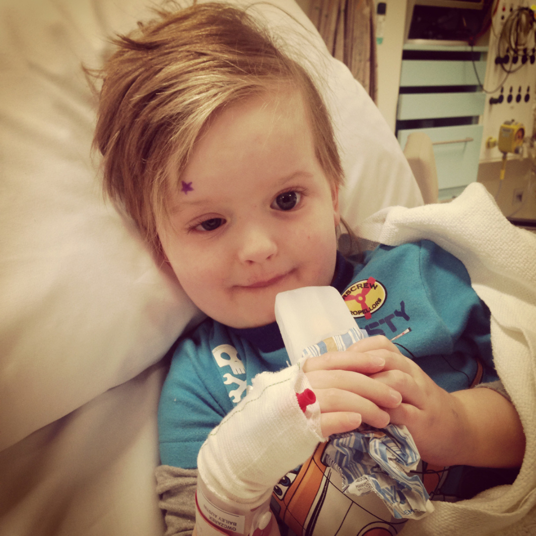 A young boy sits in a hospital bed