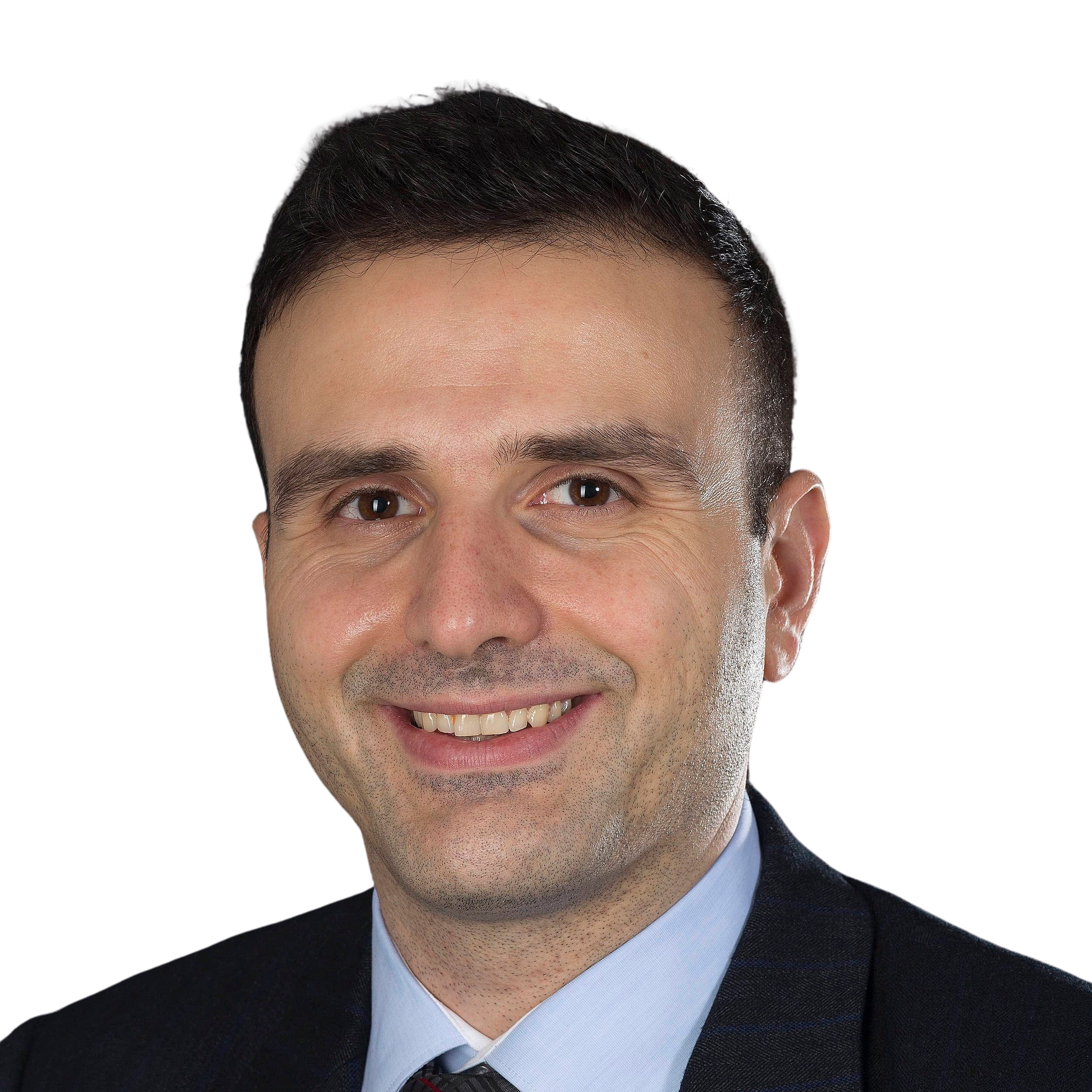 A headshot of a smiling man with black hair, wearing a black suit jacket, light blue shirt and dark patterned tie.