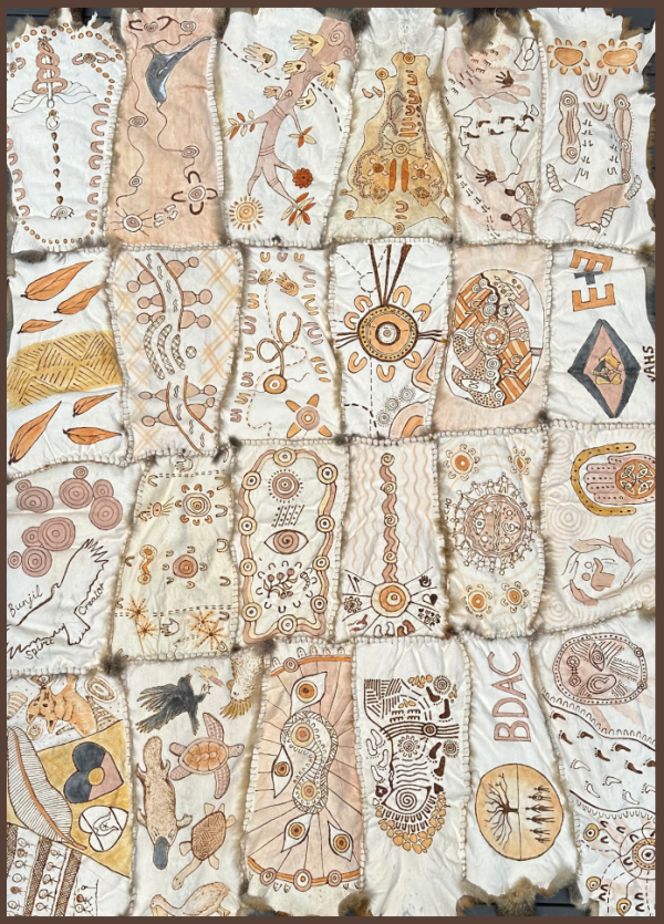 A photo of the Eye and Ear possum skin cloak, comprised of 24 possum skin pelts sewn together which are etched with burned designs and ochre.