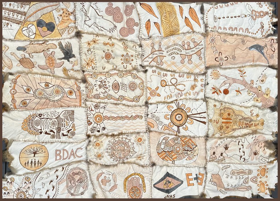 A photo of the Eye and Ear possum skin cloak, comprised of 24 possum skin pelts sewn together which are etched with burned designs and ochre.