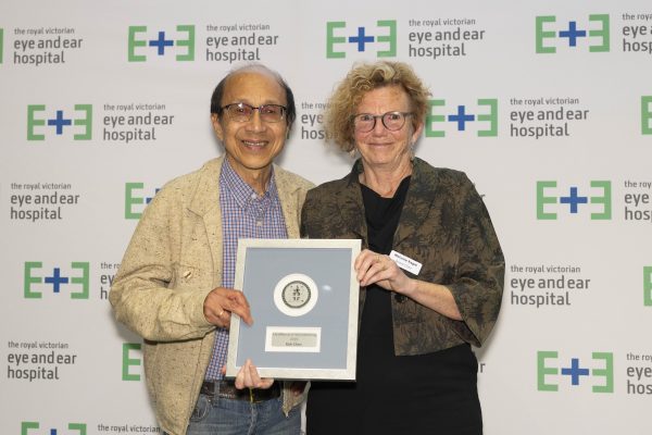Volunteer Kok Chan (left) holding the volunteer award with Board Chair Melanie Eagle.